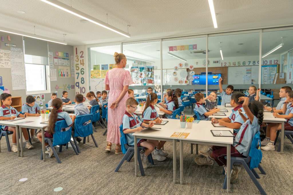 Teacher teaching a modern classroom with students actively engaged.